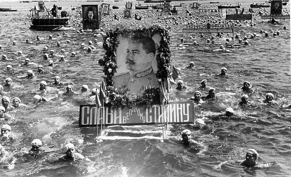 Soviet sailors swimming with floats with portraits of stalin in celebration of ussr navy day, sevastopol, ussr, july, 1950