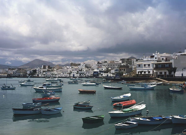 Spain, Canary Islands, Lanzarote, Arrecife, Charo de San GinAZs, white-washed fishermans cottages overlooking small boats moored on lake connected to sea