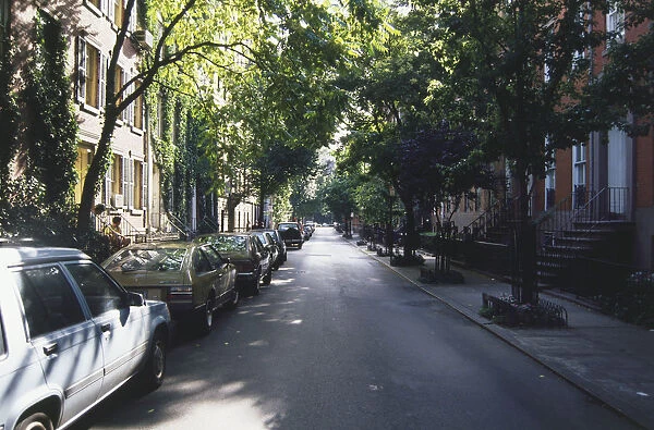 USA, New York, Manhattan, Greenwich Village, tree-lined street with cars parked on one side
