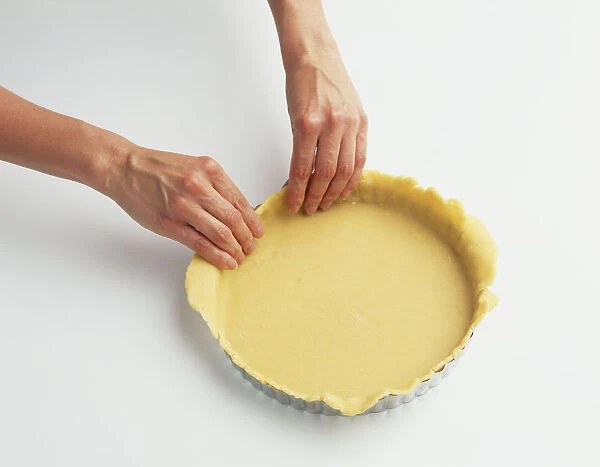 Using Floured fingers, Pastry is eased into bottom and up the sides of Baking Tin