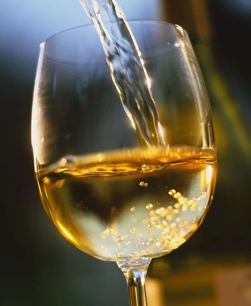 White wine being poured into a glass, close up