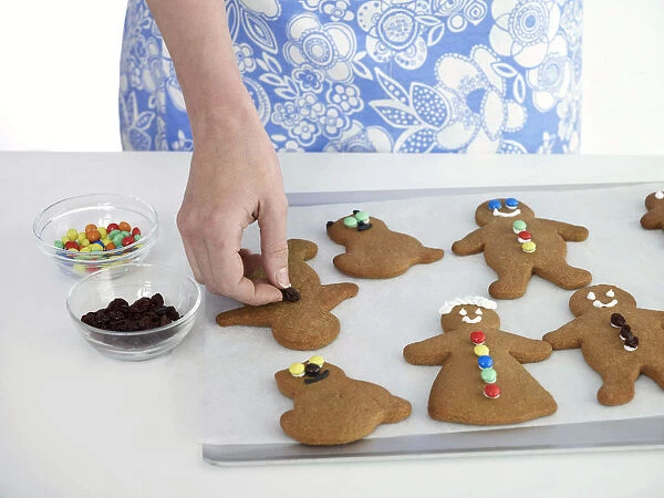 Woman decorating gingerbread cookies, close-up