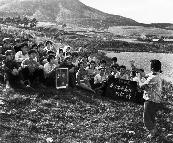 During a work break, a young woman is leading the commune workers in singing a song praising chairman mao, cultural revolution, tachai, shansi province, china, 1968