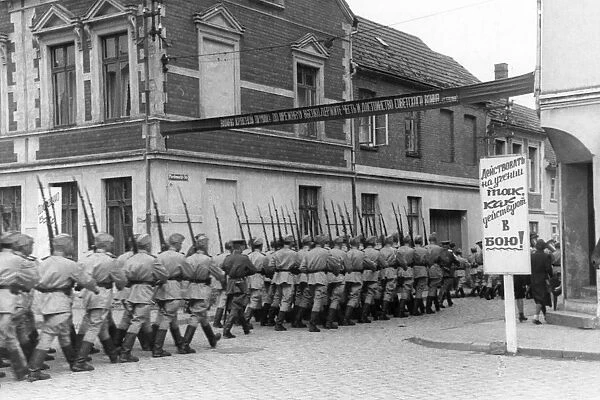 World war 2, men of a soviet garrison in germany marching to the drill grounds, july 1945, sign reads: approach learning the same way as one would approach going to battle