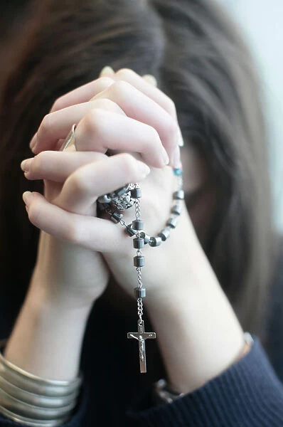 Young woman praying the rosary