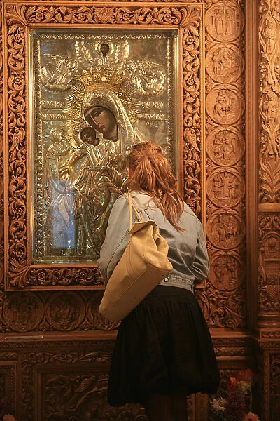 Young woman praying in Saint Dimitrios orthodox church