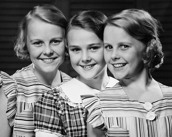 Three smiling girls (12-13) in row, (B&W), portrait
