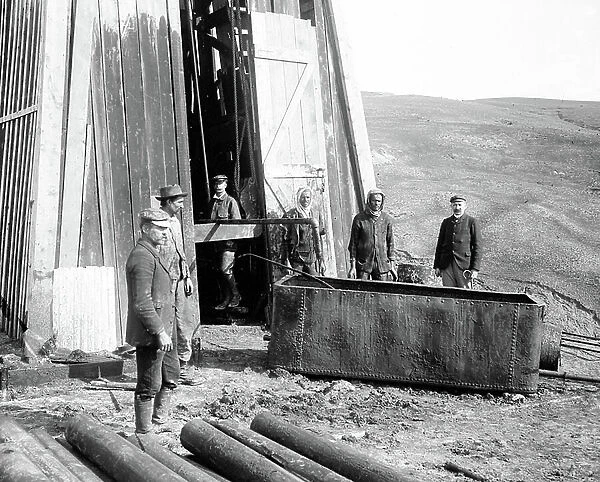 Algeria, Ain zeft: base of a derrick with workers and technicians watching the oil sink, 1904