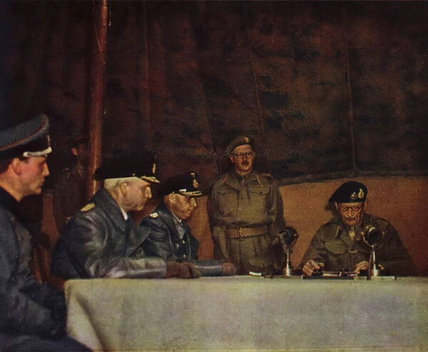 British Field Marshal Bernard Montgomery reading the terms of the surrender of German forces in Northwest Europe to Admirals Friedeburg and Wagner, Luneburg Heath, Germany, 4 May 1945 (photo)
