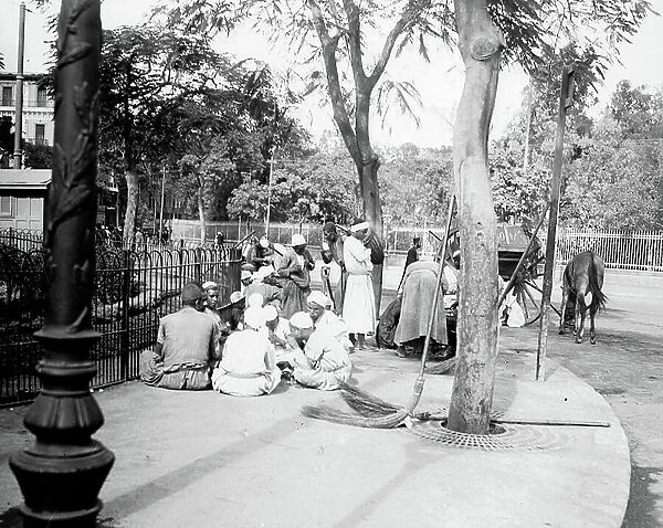 Egypt, Cairo: Cook cruise, Nile side, sweepers sitting on the sidewalk smoke the shisha, 1900
