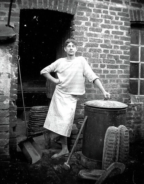 France, Centre, Indre-et-Loire (37): a mitron baker placed on the back of a bakery, next to the bakery with bread mould and coal shovel, 1900