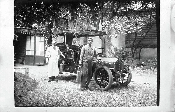 France: The driver and gardener fill the engine of a cart De Dion Bouton, 1910 - Famille De Noiron