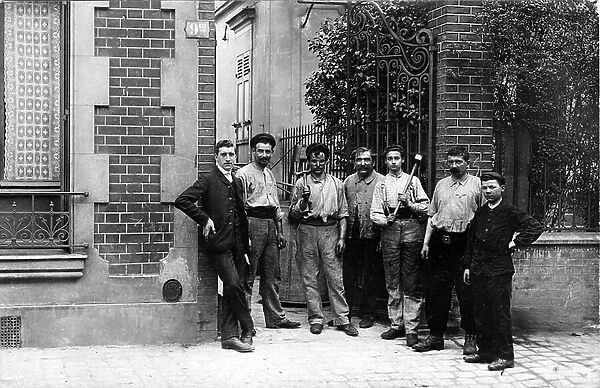 France, Ile-de-France, Paris (75): A young boss and his workers pose at the door of a workshop with their tools, 1910