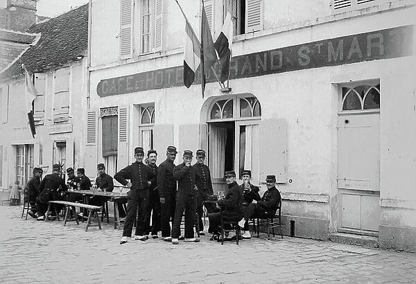 France, Ile-de-France, Seine-et-Marne (77), Beaumont du Gatinais (Beaumont-du-Gatinais): August 1899, gate of the cafe and hotel of the Grand Saint-Martin with soldiers attable to the terrace