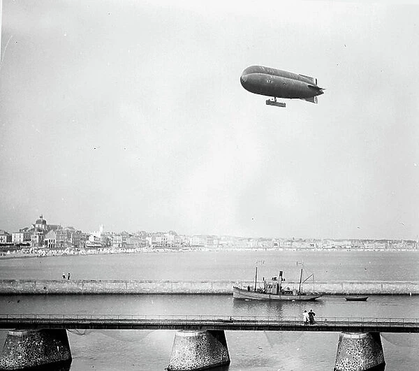 France, Pays de la Loire, Vendee (85), Les Sables-d'Olonnes: the channel with a boat returning to the port and above it, passes an airship, 1918 - airship: AT4