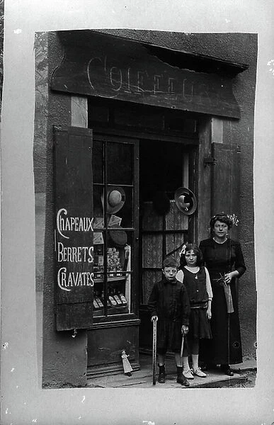 France: In a village, front of a hairdresser selling hats, berets and ties, 1910