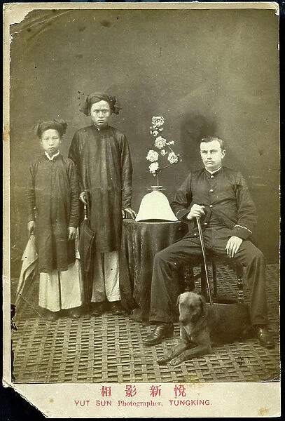 Hanoi: a soldier of the French colonial army poses in studio with his two boys and his dog, 1885