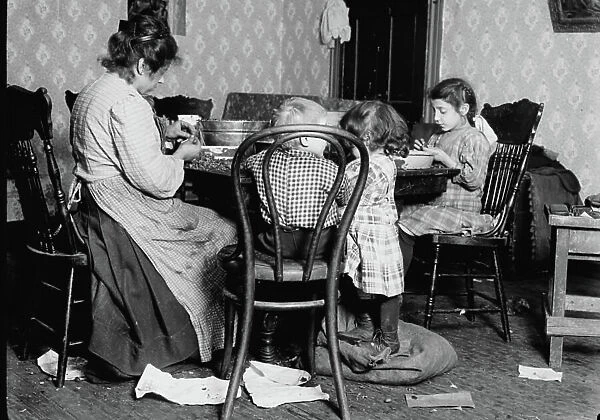 Italian Family picks nuts in their apartment, NY, 1911 (b / w photo)