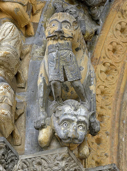 A monster devore a man - Carved detail of the vessure of the portal of the church of Sainte Marie (11th century) in Oloron Sainte Marie (Pyrenees Atlantiques, Aquitaine)