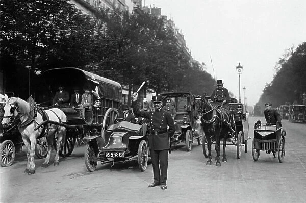in Paris, first stick for policemen c. 1910. the car behind the policeman is a 'Clement-Bayard'