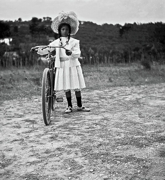 Portrait of a girl with her bicycle on a country road