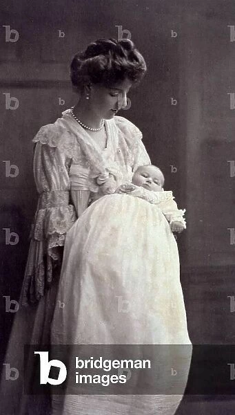 Portrait of young mother holding her infant son in her arms. Both are in cerimonial attire