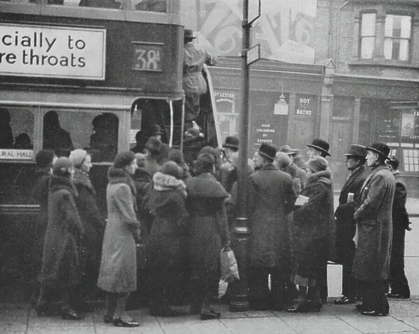 Queue for a London bus during rush hour (b / w photo)