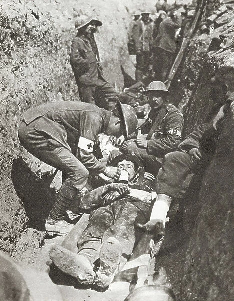 Stretcher bearers giving aid to a soldier lying wounded in a trench on The Somme, France during World War I (litho)