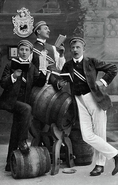 Students jam singing near beer barrels. Photography around 1910