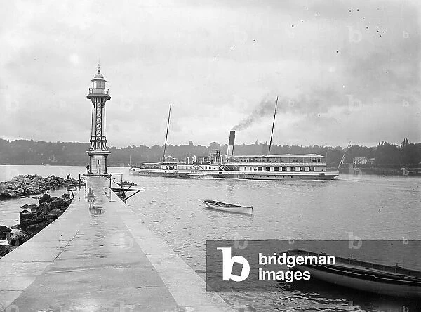 Switzerland, Canton of Geneve, Geneve: a wheeled boat with blades with a chimney Switzerland returns to the port of Geneve, in the background, the lighthouse, 1900