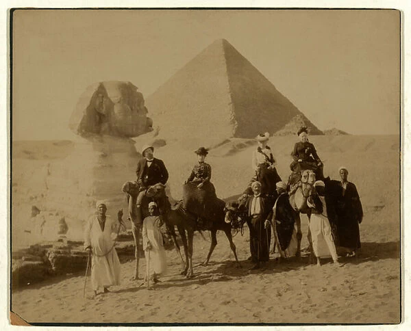 Tourists on camels in front of The Great Pyramid and Sphinx at Gaza, Egypt, pub