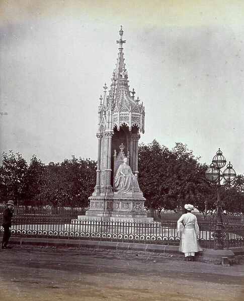 View of a park in Bombay. In the foreground the monument to Queen Victoria first Empress of India