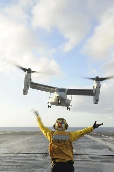 Aviation Boatswains Mate signals an MV-22 Osprey to land