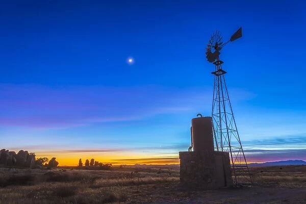 Crescent moon beside Mars and above Venus, framed by a windmill, New Mexico