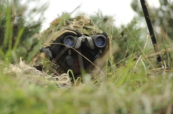 A German Bundeswehr soldier camouflages himself to blend into his surroundings