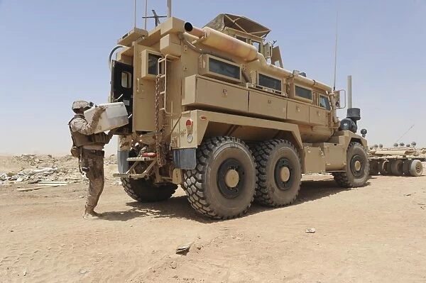 Hospital Corpsman loads up a Mine Resistant Ambush Protected vehicle