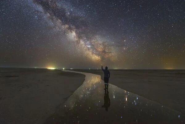 A man walking on the salt river at night under the Milky Way, Russia
