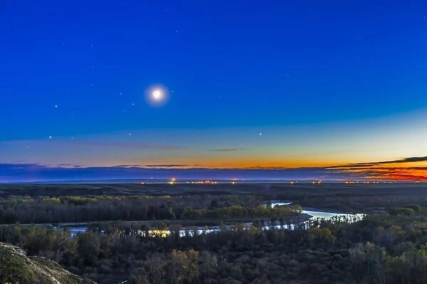 Moon with Antares, Mars and Saturn over Bow River in Alberta, Canada