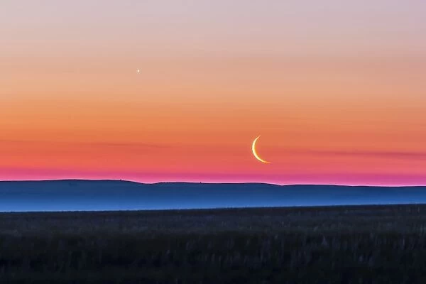 Moon and Venus rising over the flat prairie horizon of Alberta, Canada