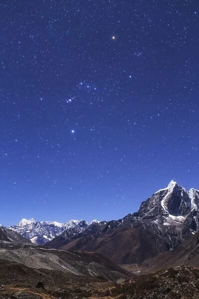 The Orion constellation above the moonlit landscape of the Himalayas in Nepal