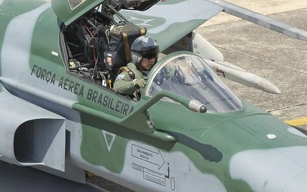 A pilot sitting in the cockpit of a Brazilian Air Force F-5 aircraft