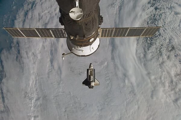 Space Shuttle Discovery with a Russian spacecraft visible in the foreground