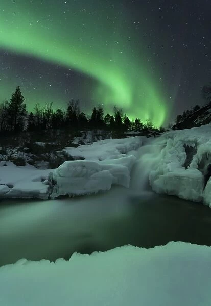 A wintery waterfall and aurora borealis over Tennevik River, Norway