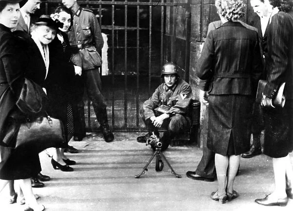 Civilians in front of a German guard post with a machine gun, Paris, June 1940