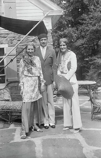 Pierre de Beaumont and two unidentified women, standing outdoors, between 1932 and 1942. Creator: Arnold Genthe