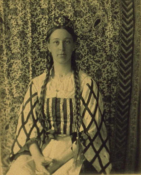 Portrait of a woman with braids in front of a paisley backdrop, c1900. Creator: Frances S. Allen