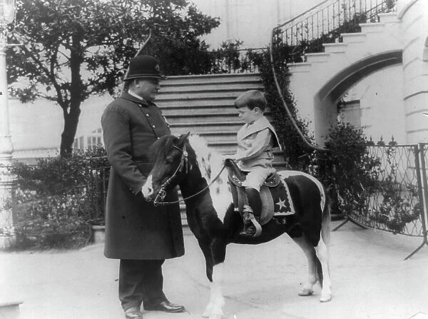 Quentin Roosevelt on pony beside White House policeman, 1905. Creator: Frances Benjamin Johnston
