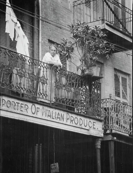 Woman leaning on a balcony, New Orleans, between 1920 and 1926. Creator: Arnold Genthe