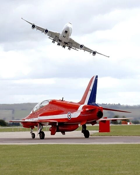 On Boeing 747 Swoops Over a Royal Air Force Red Arrow at Air Show