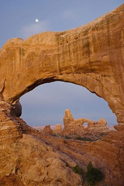 Arches National Park, Utah, United States Of America; Turret Arch Seen Through The North Window At Sunrise With A Full Moon Above